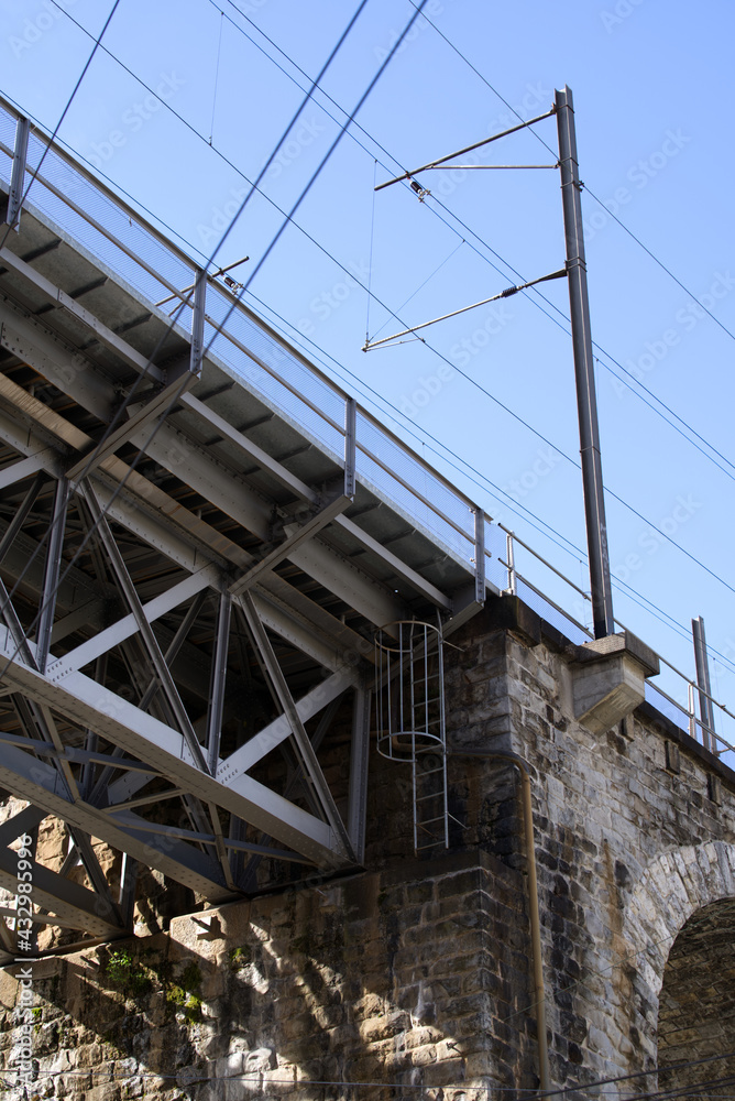Close-up of iron railway bridge with stone pillars at industrial district at City of Zurich. Photo taken May 10th, 2021, Zurich, Switzerland.