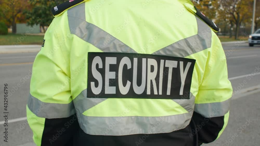 Tracking shot of security guard in uniform patrolling the commercial area.