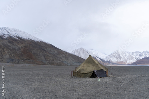Indian military tent in an abandoned place in ladakh with beautiful snow mountains in background.