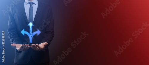 Businessman in a suit holds a sign showing three directions. in doubt, having to choose between three different choices indicated by arrows pointing in opposite direction concept. three ways to choose