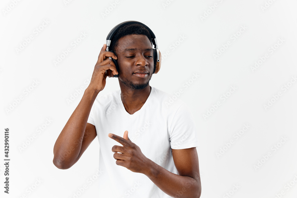 Fototapeta premium man of african appearance with closed eyes in headphones listening to music