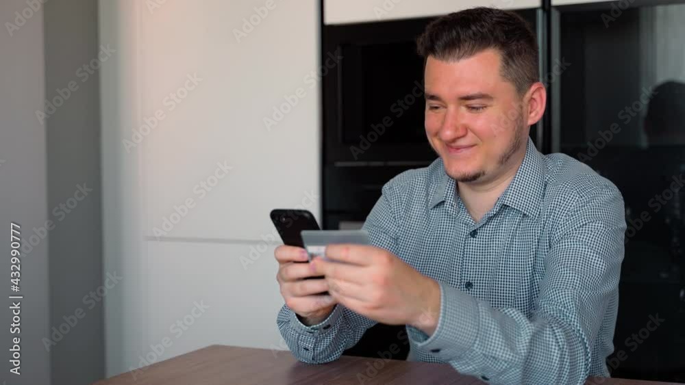 Portrait of Caucasian 30s man shopping online with smartphone and credit card at home indoors. Ease of online shopping with modern technology concept Portrait of Caucasian 30s man shopping online with smartphone and credit card at home indoors. Ease of online shopping with modern technology concept