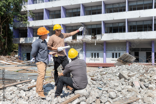 Demolition control supervisor and contractor discussing on demolish building.