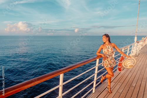 Cruise ship vacation travel luxury Caribbean holiday tourist woman watching sunset from balcony deck. Happy Asian woman enjoying holidays. © Maridav