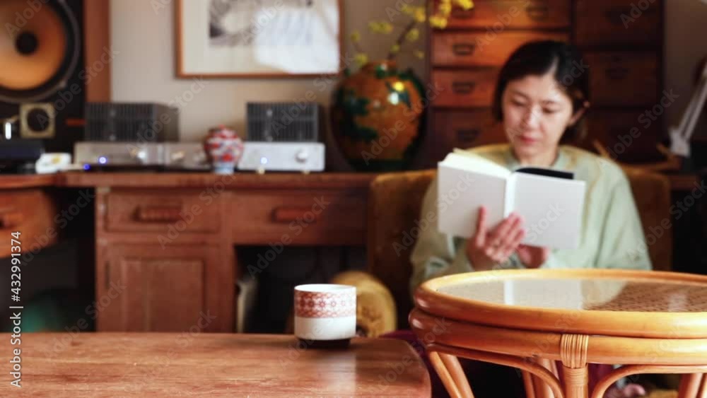 テーブルの上のコーヒーカップと読書する日本人女性 テーブルの上のコーヒーカップと読書する日本人女性