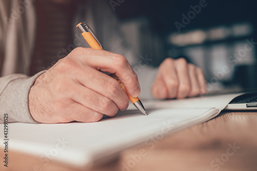 Freelance worker writing yo do list at home office desk