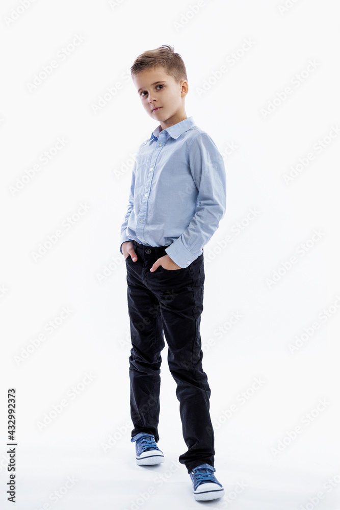 A serious boy of 7 years old is standing. Full height. White background. White background. Vertical.