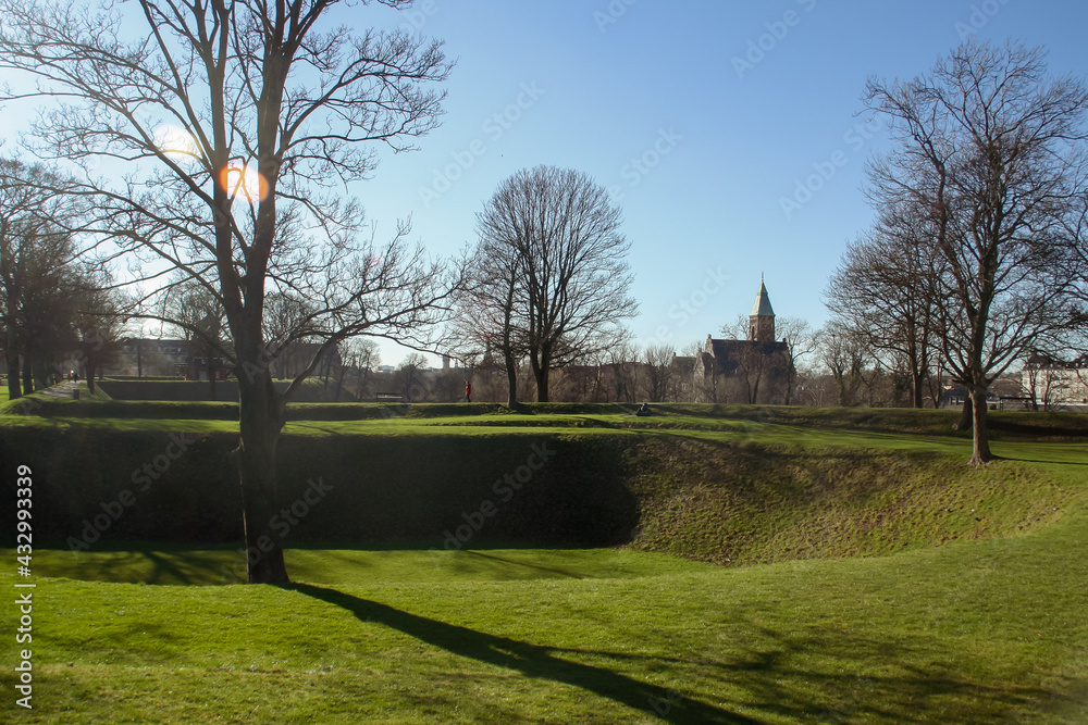 Kastellet, (inglés: The Citadel) ubicado en Copenhague, Dinamarca. Los muros defensivos cubiertos de hierba junto al canal de la ciudadela.