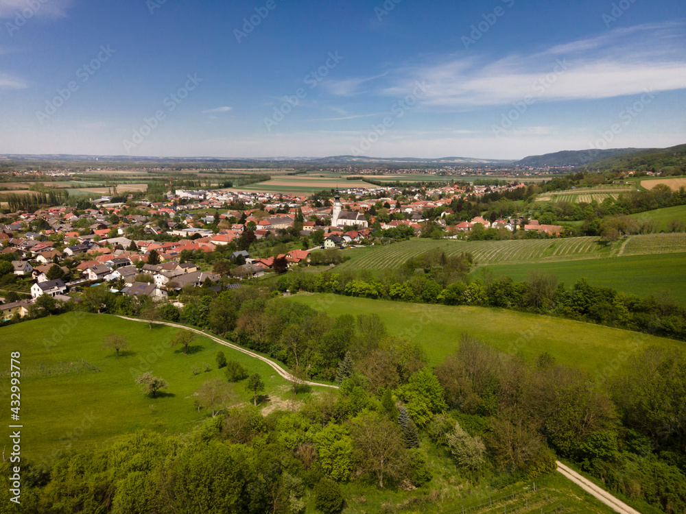 aerial drone flight photo of green hills, meadows and fresh forest in Lower Austria at the edge of Vienna Woods on a sunny day
