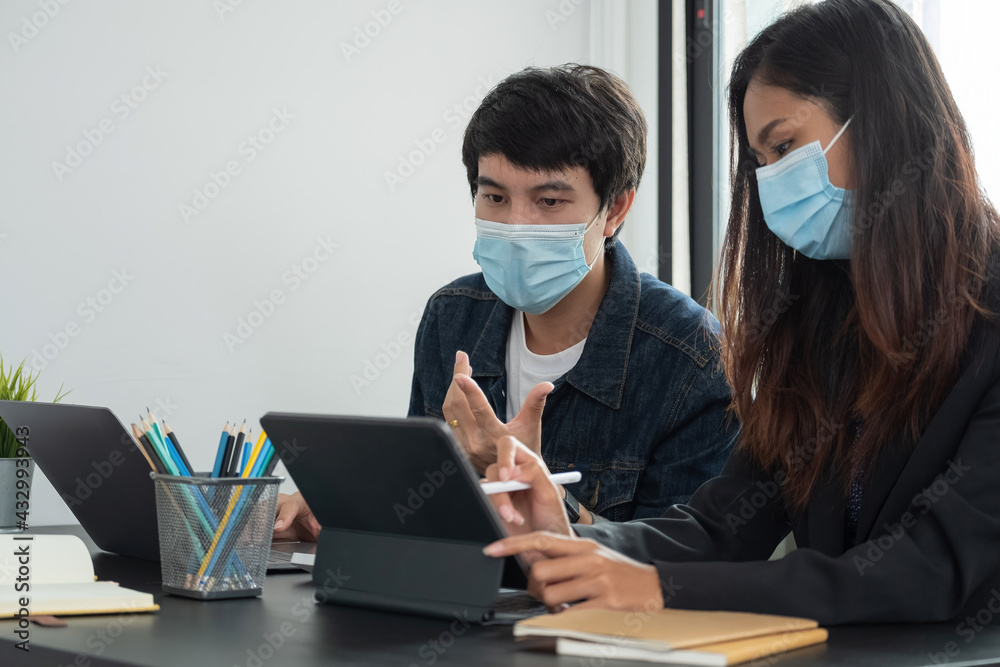 Asian business people have a meeting and working in office and wear mask as protection from corona virus. Asian business people have a meeting and working in office and wear mask as protection from corona virus.