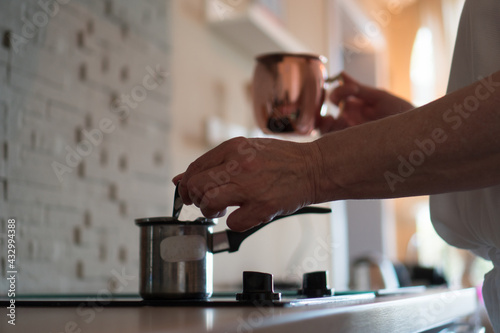 Close-up shot of the senior woman's hand while she is preparing the coffee.