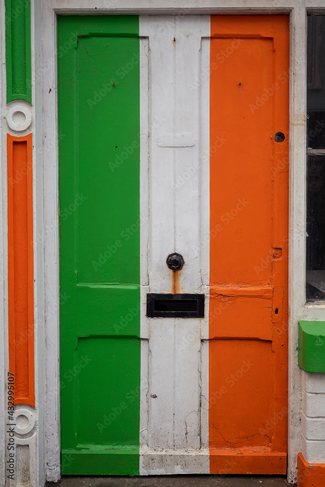 Old weathered door painted in colors of Irish National flag. Rich saturated colors. Expression of pride, love and patriotism to your country