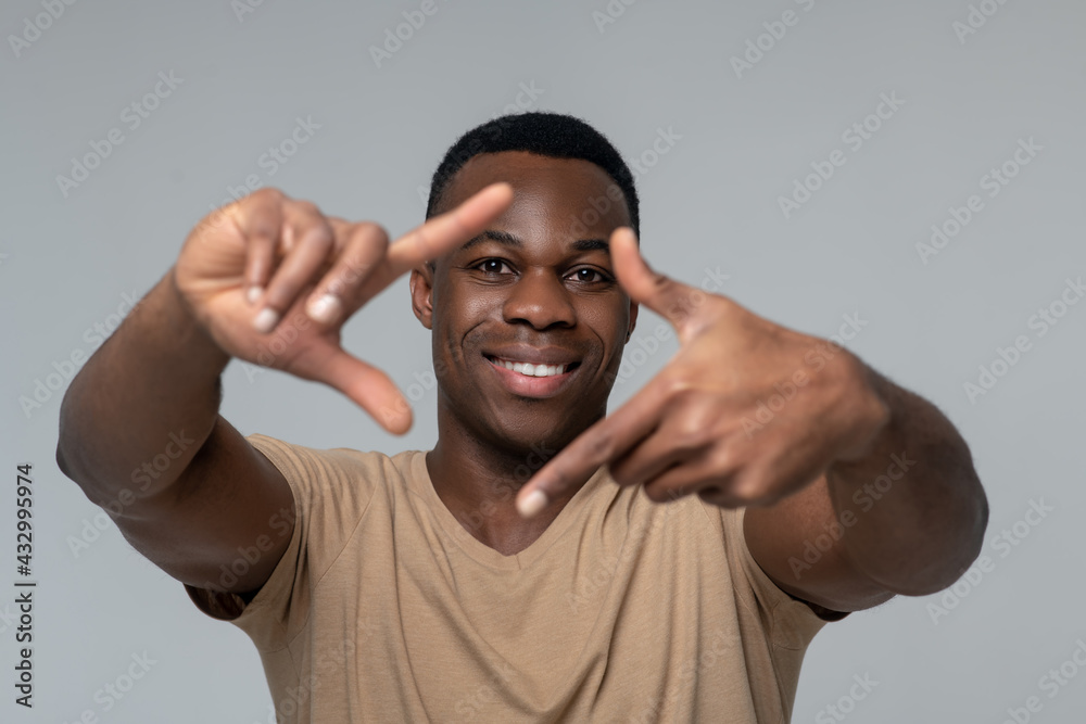 Smiling man showing air lens with hands Smiling man showing air lens with hands