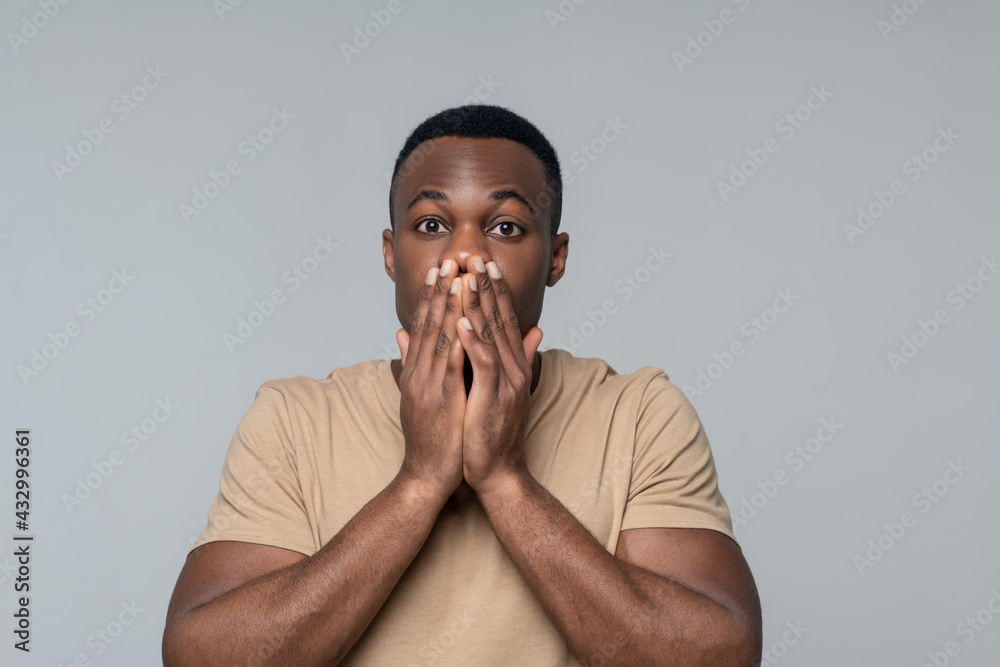 Surprised man covering his mouth with hands
