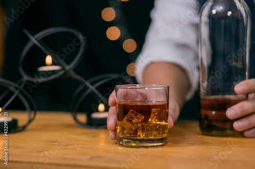 Barman pouring whiskey glass on beautiful bokeh background