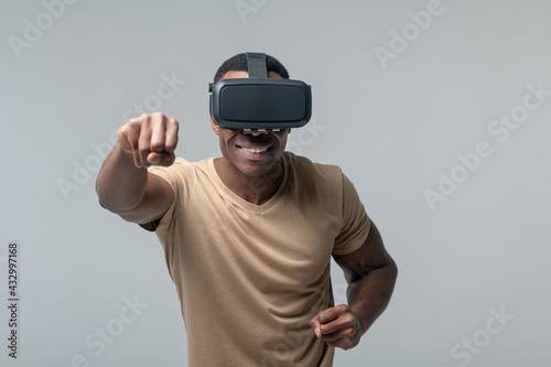 Cheerful man in VR glasses waving his fists