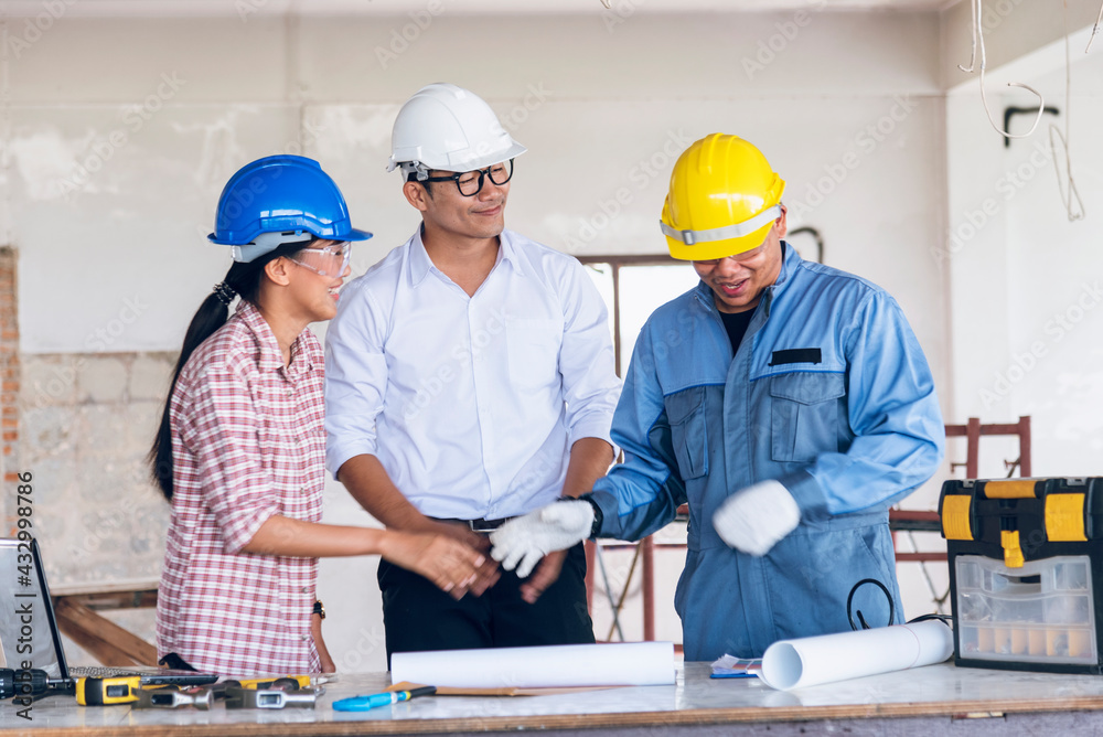 Construction engineer teamwork Safety Suit Trust Team Holding White Yellow Safety hard hat Security Equipment on Construction Site. Hardhat Protect Head for Civil Construction Engineer Concept