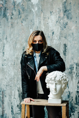 Young woman in black medical mask in art studio