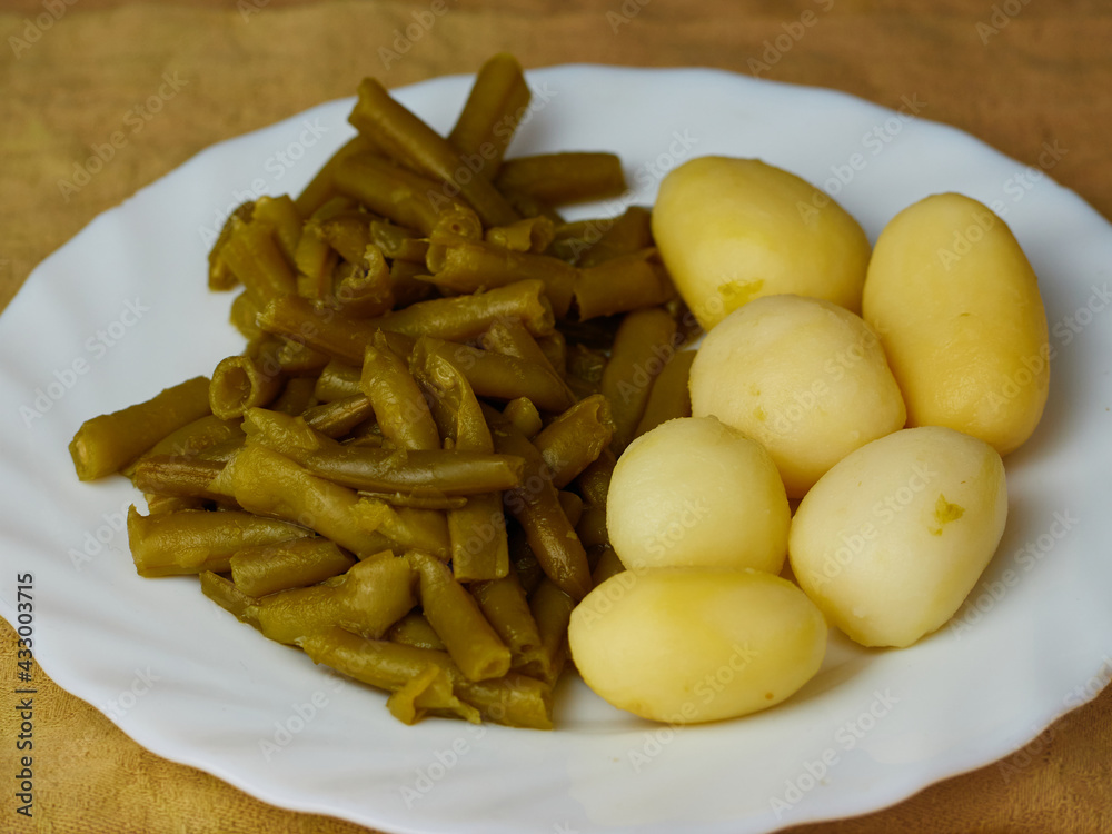 Tasty Green beans and potatoes on a plate on a brown napkin Tasty Green beans and potatoes on a plate on a brown napkin