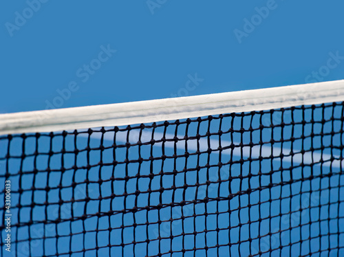 Blue paddle and tennis net and hard court. Professional sport and tennis competition concept © Augustas Cetkauskas