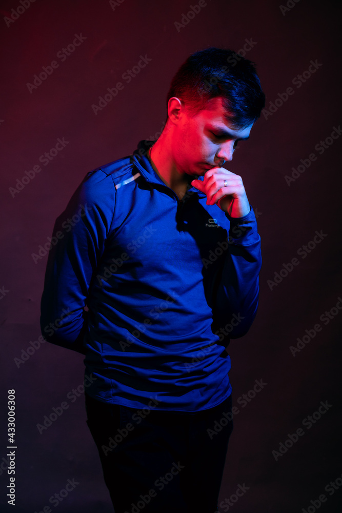 Emotions of a guy in a studio with blue and red light on a black background Emotions of a guy in a studio with blue and red light on a black background