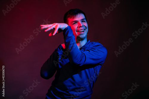 Emotions of a guy in a studio with blue and red light on a black background © ISliM
