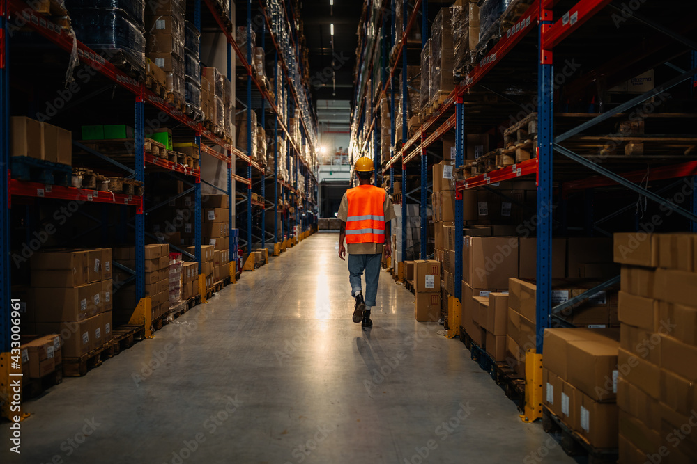Male worker oversize shelves in warehouse
