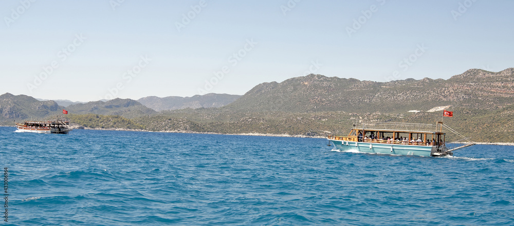 Swimming pleasure boats with tourists on board