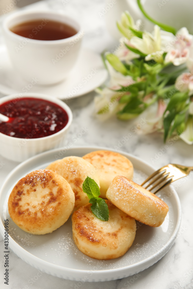 Delicious cottage cheese pancakes with mint and icing sugar on white marble table