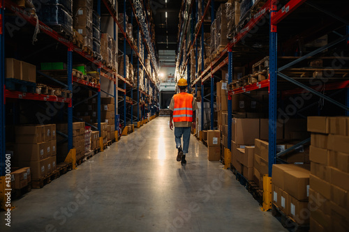 Male worker oversize shelves in warehouse