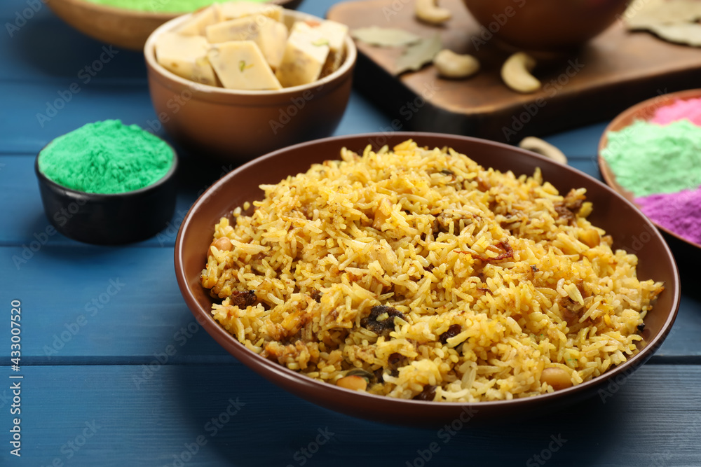 Traditional Indian food and color powders on blue wooden table. Holi festival celebration Traditional Indian food and color powders on blue wooden table. Holi festival celebration