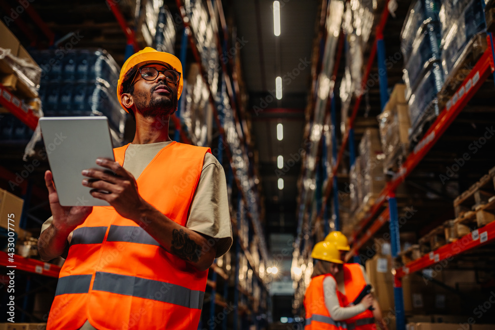 Worker using digital tablet at warehouse