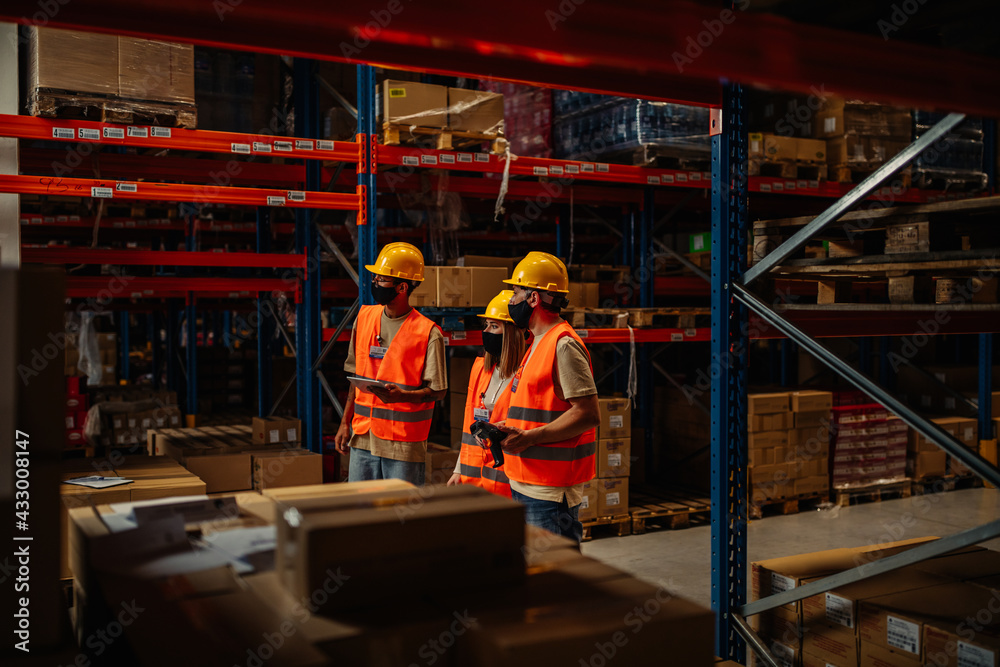 Obraz premium Manager with coworkers controlling stock in factory warehouse