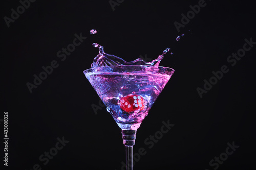 Photography Casino dice falling into glass of alcohol drink on black background