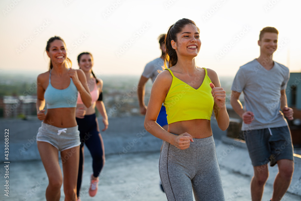 Group of happy fit friends exercising together outdoor