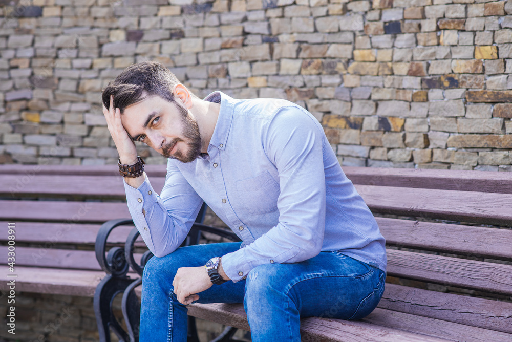 Portrait of a man who sits on a bench and thinks Portrait of a man who sits on a bench and thinks