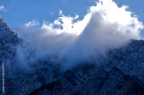 Beautiful view of cloudy rock mountain tops in Logarska Dolina settlement, Logar Valley, Slovenia photo