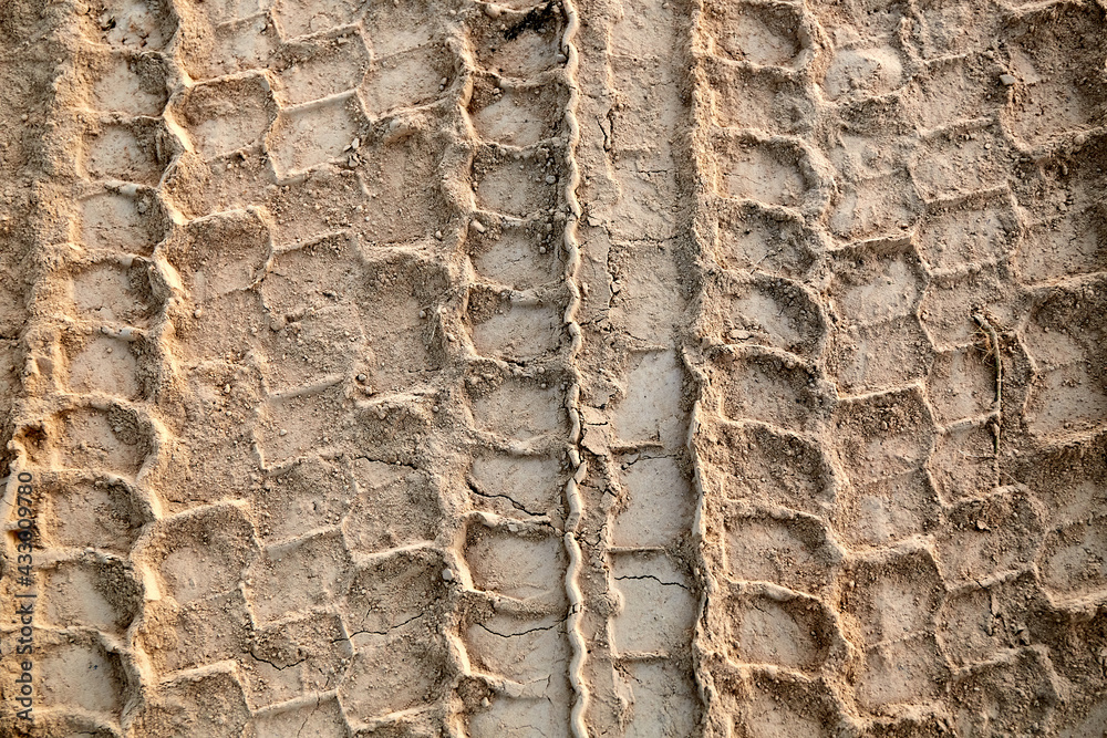 Tire tread footprints of a dump truck on the sand. Construction site. Pattern. Brown abstract background. Car wheelprint. Textured ground. Tyre drawing Tire tread footprints of a dump truck on the sand. Construction site. Pattern. Brown abstract background. Car wheelprint. Textured ground. Tyre drawing