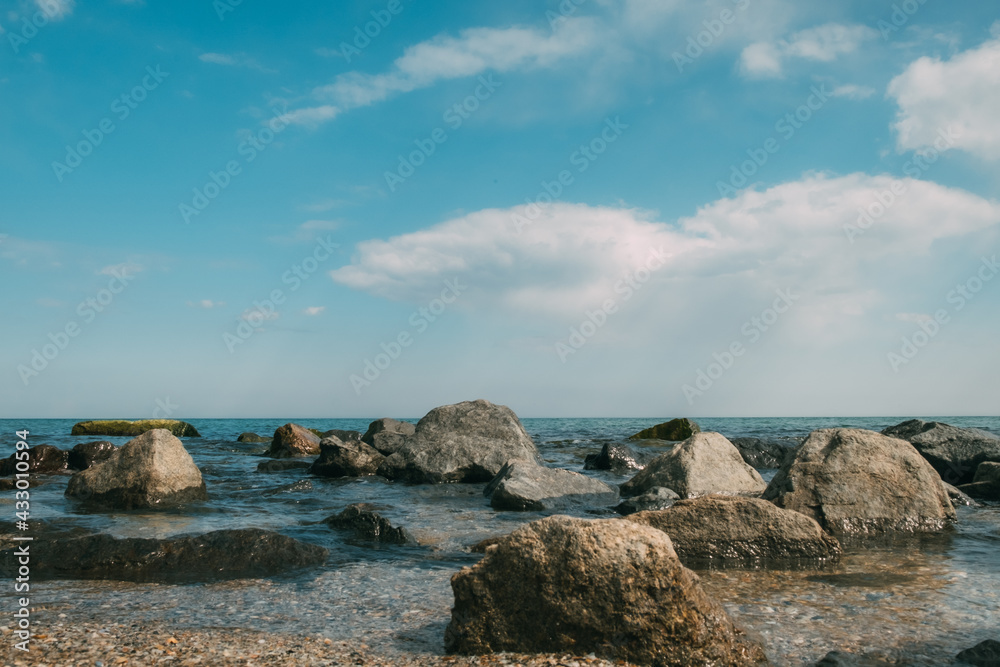 Sea view through stones. Reflection of stones