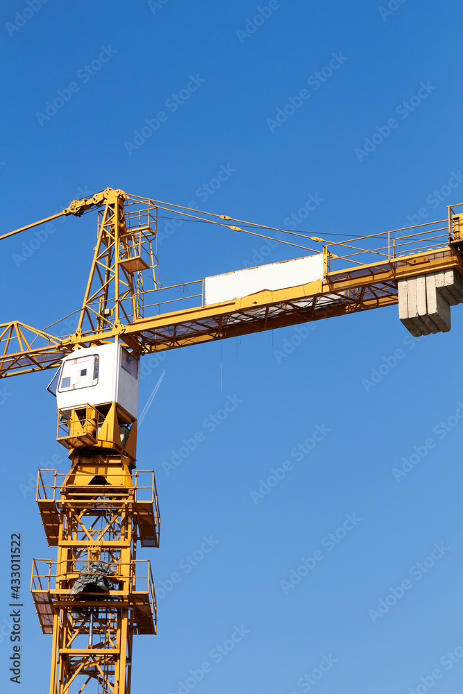 High tower construction crane with blue sky background. High tower construction crane with blue sky background.