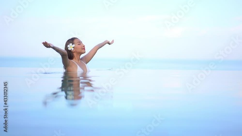 Summer Girl in Relaxing in Swimming Pool Spreading Arms, Soft Focus. photo