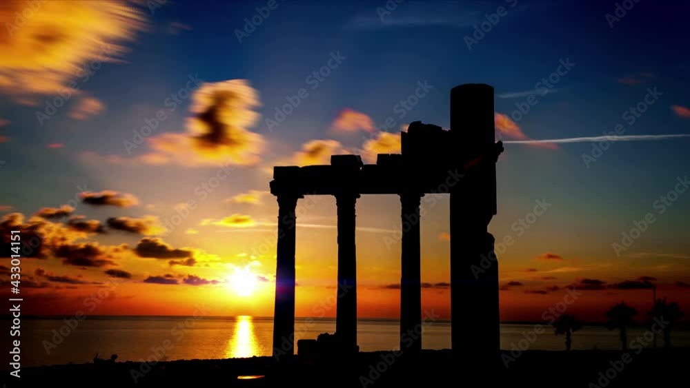 Columns of ancient Greek ruins against the backdrop of sunset. Sunset timelapse with orange sky. time lapse