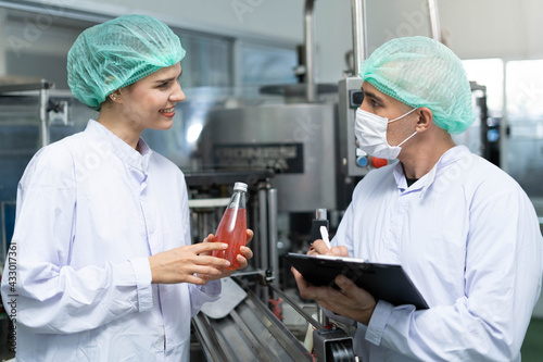 A quality supervisor or a food or pharmaceutical technician inspects the quality of food and drugs before sending the product to the customer. Employees are in an industrial water containment chamber.