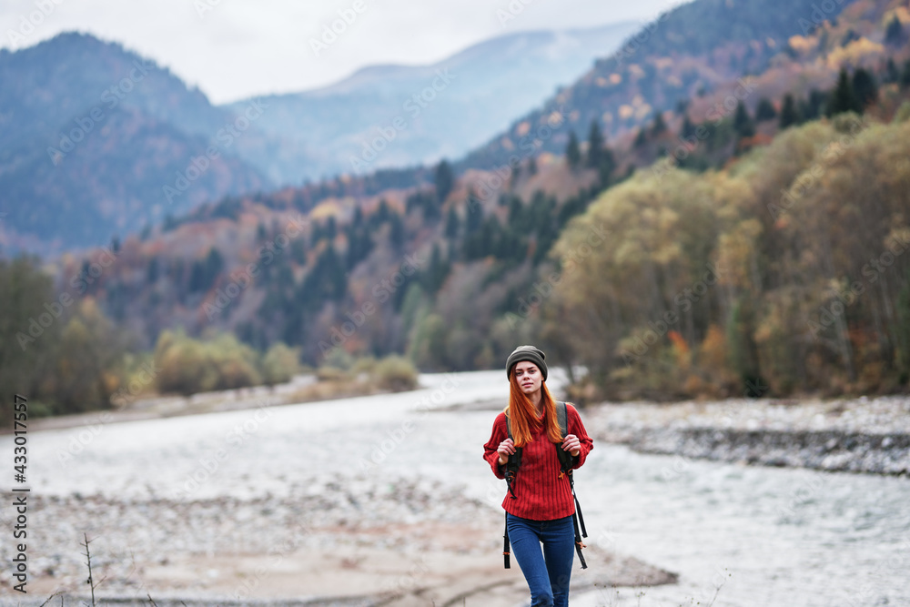 hiker with a backpack on the banks of the river in the mountains and landscape morning model tourism