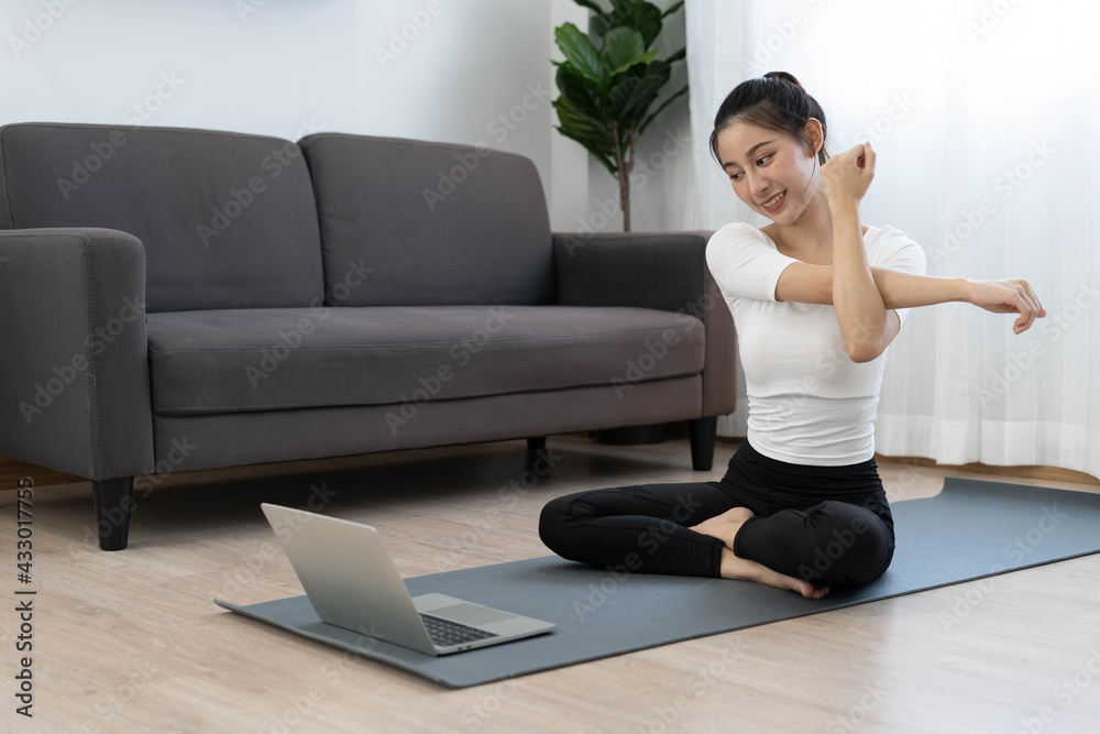 Asian women exercise at home with online video tutorials on the internet. Healthy exercise ideas Asian women exercise at home with online video tutorials on the internet. Healthy exercise ideas