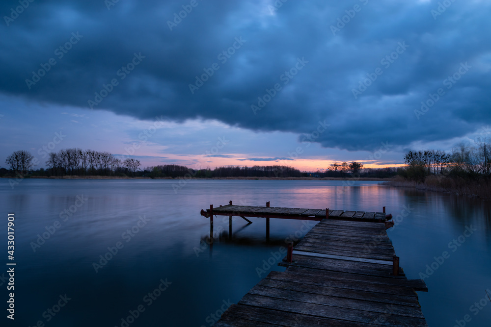 Fishing pier on the lake and the evening sky