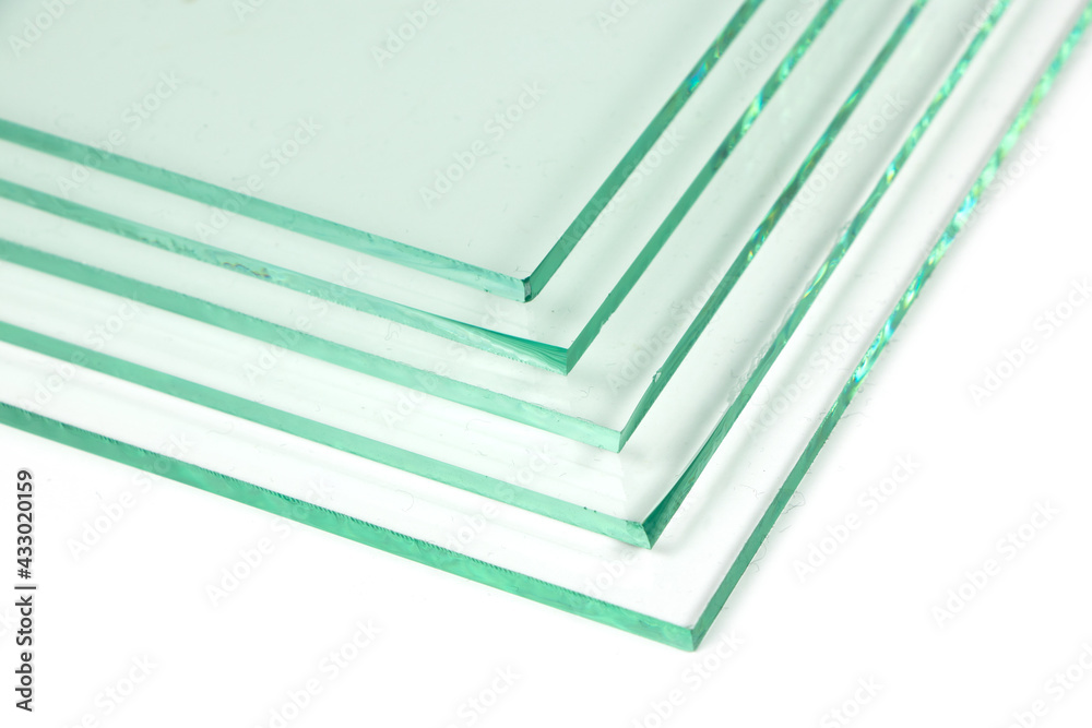 Sheets of Factory manufacturing tempered clear float glass panels cut to size. White background Sheets of Factory manufacturing tempered clear float glass panels cut to size. White background
