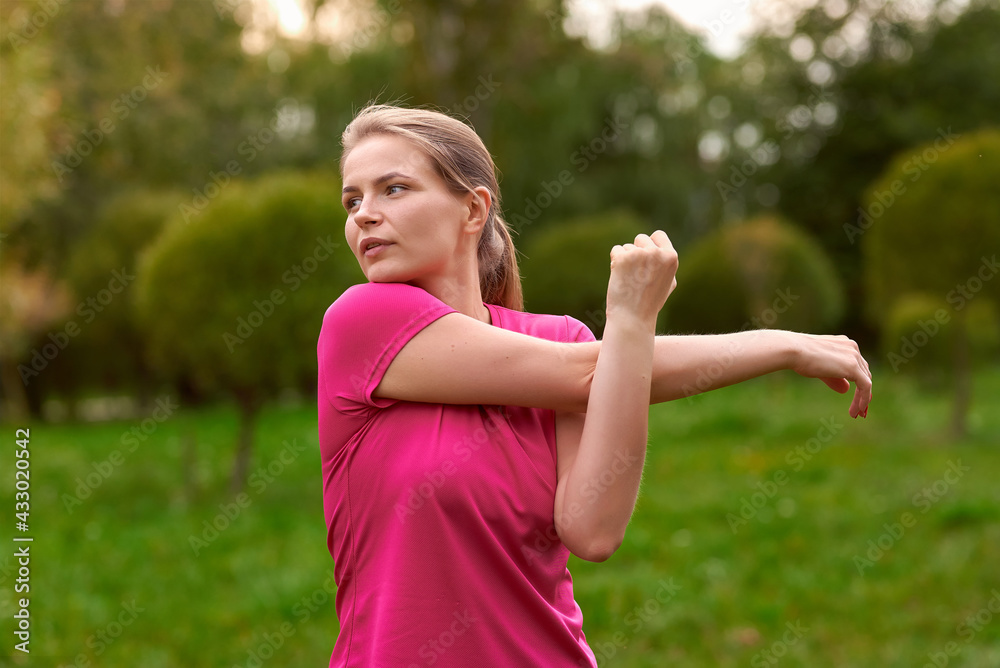 young woman in sportswear trains in the park outdoors young woman in sportswear trains in the park outdoors