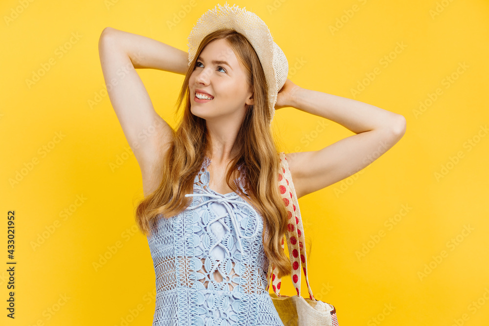 Dreaming young woman, in summer clothes and in a straw hat, on a yellow background, thinking concept Dreaming young woman, in summer clothes and in a straw hat, on a yellow background, thinking concept