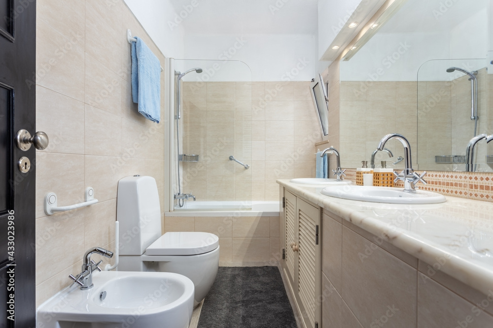 A shot of a bathroom with a marbled sink facing a toilet and a bathtub next to it. Clean looking appearance. A shot of a bathroom with a marbled sink facing a toilet and a bathtub next to it. Clean looking appearance.
